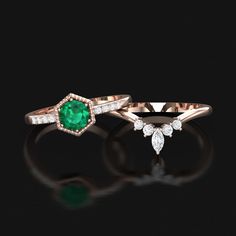 an emerald and diamond ring set on a black background with the top one in white gold