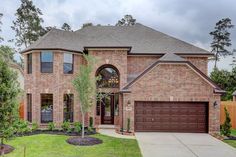 a large brick house with two garages in the front yard and landscaping around it