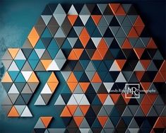 an abstract geometric design with orange and gray triangles on a blue background that is made up of smaller triangulars