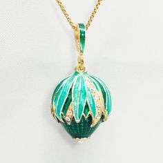 "Enameled and24K gold plated over solid sterling silver, egg- pendant created in the spirit of Faberge jewelry. The lower part of the pendant is covered with translucent emerald green  enamel and has a tiny pearl at the center of the flower at the bottom. The leaves of the upper part of the egg corn are teal and green with  a few leaves between them decorated by clear crystals, adding to the brightness of the pendant.   I added pictures of other color variations of this pendant, which may be ava Enamel Round Pendant Necklace For Anniversary, Anniversary Enamel Round Pendant Necklace, Oval Pendant Enamel Necklace For Gift, Enamel Oval Pendant Necklace For A Gift, Teardrop Detachable Pendant Jewelry Gift, Oval Enamel Necklace For Gift, Oval Enamel Jewelry For Gift, Anniversary Pendant Necklace In Enamel, Green Pendant Necklace For Keepsake