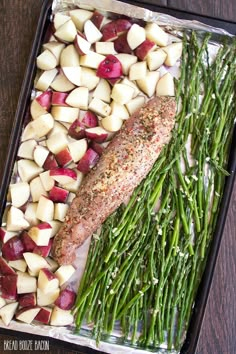 fish, potatoes and asparagus on a baking sheet ready to be cooked in the oven