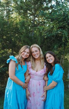 three women in dresses posing for the camera