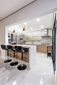 a kitchen with marble counter tops and bar stools