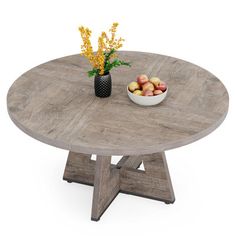 a bowl of fruit on top of a wooden table next to a vase with flowers