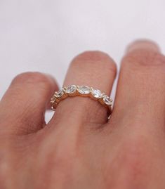 a woman's hand with a ring on it that has three stones in the middle