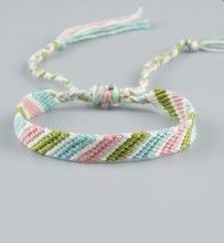 the bracelet is made with multicolored yarn and has a knot on it's end