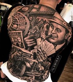 the back of a man's shoulder with tattoos on it, including an image of a