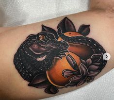 a close up of a person's arm with a tattoo on it and an orange