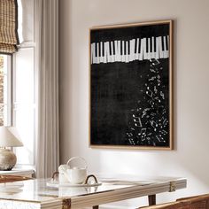 a blackboard with white piano keys hangs above a dining room table in front of a window