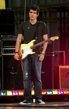 a man standing on stage with a guitar