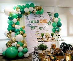 a birthday party with balloons, decorations and zebras on the table in front of it