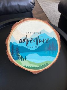 a piece of wood that says and so the adventure begins on top of a table