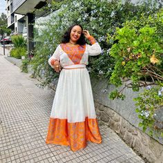 Description Embrace the warmth of the Ethiopian sunset with the simplicity and grace of the Habesha dress adorned in radiant orange hues. This elegant garment, known as the Habesha Kemis, celebrates the beauty of simplicity with its clean lines and understated design. The vibrant orange color evokes the vivid hues of an African sunset, infusing the attire with a sense of energy and vitality. Each stitch in the Ethiopian dress is a testament to the rich cultural heritage and craftsmanship of Ethi Bohemian Orange Floor-length Dress, Traditional Orange Tunic Dress, Orange Anarkali Floor-length Dress, Orange Anarkali Maxi Dress, Orange Floor-length Anarkali Dress, Traditional Orange Long Sleeve Dress, Orange Tunic Dress For Festival, Traditional Long Sleeve Orange Dress, Festive Orange Floor-length Maxi Dress