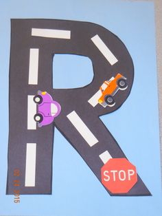 the letter r is made out of paper and has cars on it, along with a stop sign