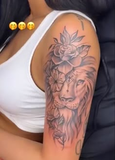 a woman's arm with a lion and roses tattoo on the left side of her arm