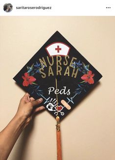 someone is holding up a graduation cap that says nurse saraah and has flowers on it