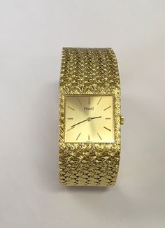 "Genuine Piaget watch with a manual movement in 18 karat yellow gold with a woven 18 karat yellow gold bracelet.  The watch measures 7\" long and 7/8\" wide.  It has a square case and gold stick dial.  Watch is in excellent condition and was serviced 1/9/2021.  Preowned.  Serial # 362124.  Model # 9352D2." Piaget Watch, Titanium Watches, Crosses Decor, Cartier Watch, Rings For Girls, Yellow Gold Bracelet, Lovely Ring, Square Watch, Dream Jewelry