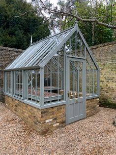 a small building with a glass roof and brick walls