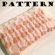 an orange and pink crocheted blanket sitting on top of a white countertop