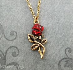 "This listing is for a hand painted red rose charm necklace. You'll be able to choose your chain length and style at checkout by using the \"Chain Length/Style\" drop-down menu. Keyrings, bangle bracelets, ball chains, and black/brown leather and suede cord are also available. **Please see the second photo for scale! If you're on the mobile site, just swipe to the side. :) ITEM CARE: We recommend avoiding contact with water, for best results. **Please note that this is gold-tone and not actually Metal Rose Design Jewelry For Valentine's Day, Vintage Rose Design Necklaces For Valentine's Day, Rose Metal Jewelry For Gift, Valentine's Day Metal Jewelry With Rose Design, Red Rose Necklaces For Gifts, Red Roses Necklaces For Gift, Red Flower Charm Jewelry For Valentine's Day, Gift Red Rose Necklaces, Red Rose Necklace For Gift