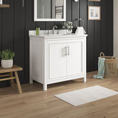 a white bathroom vanity sitting on top of a wooden floor