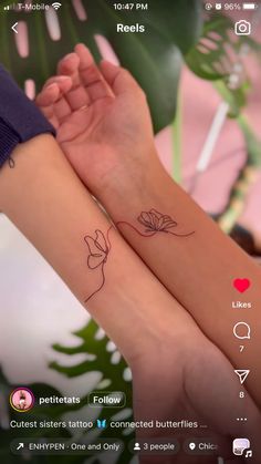 two small tattoos on both arms with flowers and leaves in the middle one is pink