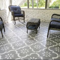 three wicker chairs sitting on top of a cement floor