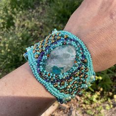 a woman's arm with a bracelet made out of beads and glass beads on it