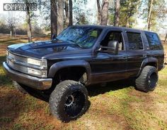 a large black truck parked in the grass