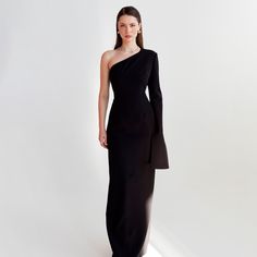 Introduced in classic black, this long dress is defined by its distinct off-the-shoulder design. The strategically placed seams and smooth satin lining make it flexible and comfortable, whether you're sitting, standing, or dancing.  The dress is made exclusively in our atelier, meaning that it is not produced or manufactured anywhere else. This adds a level of uniqueness to the garment, as it is only available from our specific location. This production process allows us to maintain a high level Classic Maxi Length Evening Dress For Gala, Classic Evening Gown Maxi Length, Classic Floor-length Maxi Dress For Evening, Classic Floor-length Evening Maxi Dress, Elegant Dress With Asymmetrical Neckline For Black-tie Events, Chic Long One Shoulder Dress For Formal Events, Elegant Off-shoulder Maxi Dress For Gala, Sleek Fitted One Shoulder Evening Dress, Chic Long One Shoulder Formal Dress