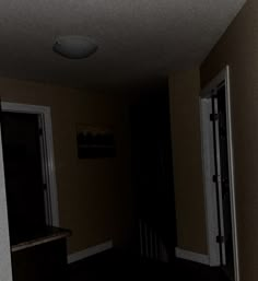 an empty hallway in a house with dark floors and white trim on the door,