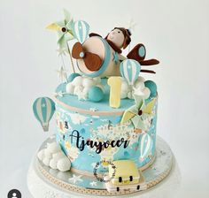 a blue and white cake with an air balloon on it's top that says, happy birthday