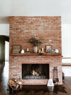 a living room with a brick fireplace and wooden floors