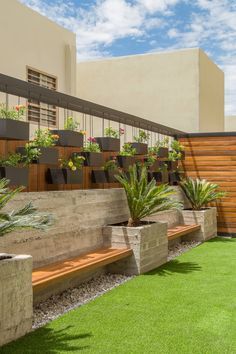 a row of planters sitting on top of a grass covered field next to a building