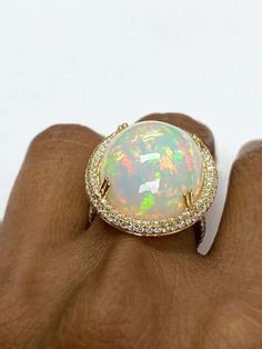 For Sale on 1stDibs - White Opal Cabochon Ring With Diamond in 18K Yellow Gold, from 'G-One' Collection Stone size: 24 X 19 mm Gemstone Weight: 19.20 Carat Diamonds G-H / VS Luxury Diamond Cabochon Gemstones, Luxury Diamond Gemstones With Cabochon Cut, Luxury Multi-stone Cabochons For Formal Occasions, Luxury Multi-stone Oval Cabochons, Luxury Yellow Gold Oval Cabochon Gemstones, Yellow Gold Multi-stone Cabochons Fine Jewelry, Yellow Gold Multi-stone Cabochons For Fine Jewelry, Luxury Diamond Cabochons For Wedding, Luxury Oval Cabochon Diamond Gemstones