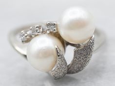 Exquisitely crafted, this white gold bypass ring features two beautiful saltwater pearls and diamond accents. The intricate design makes this special piece a timeless classic.Metal: 10K White GoldGem: 2 Saltwater PearlsGem Measurements: 6.3 mm, RoundAccents: 3 Diamonds totaling .04 Carats, SI-I in Clarity, G-H in ColorRing Size: 6Marks: "RESCO 10K" Stamped on the inside band White Gold Pearl Ring, Pearl Ring Vintage, Vintage Pearl Ring, Pearl Rings Vintage, Ring Pearl, Silver Gift Wrap, Gold Pearl Ring, Saltwater Pearls, Pearl And Diamond Ring