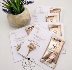 wedding stationery with flowers in a vase and some cards on the table next to it