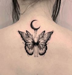 the back of a woman's neck with a butterfly and crescent tattoo on it