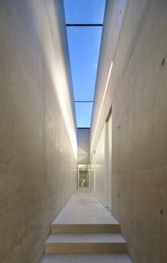 an empty hallway with stairs leading up to the sky