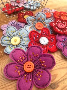 several different colored flowers on a wooden table