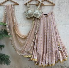 A three-piece nude butti mirror lehenga set from the Priti Sahni collection. This elegant nude butti georgette lehenga with big ruffle detailing and gota border is paired with our classic pearl work and mirror bustier. The lehenga has side hanging ball tassels to the waistline. And the blouse has a mirror-sequins tassel tie-up at the back. The outfit is completed with a nude sequined butti work dupatta with scalloped edging. Ruffle Lehenga, National Institute Of Design, Embroidered Bustier, Raw Silk Blouse, Cape Fashion, Math Shirts, Ocean Green, Scalloped Border, Green Sequins