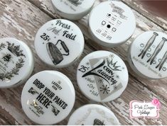 some white buttons with black and white designs on them, sitting on a wooden surface