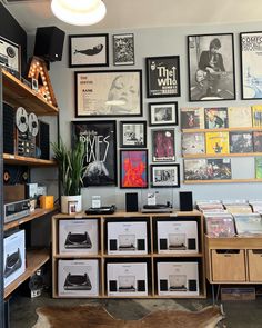 a room filled with lots of records and pictures on the wall next to a desk