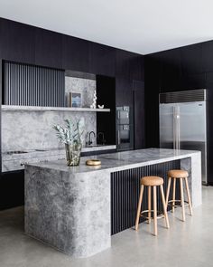 a kitchen with marble counter tops and stools next to an island in the middle