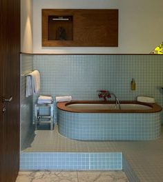 a bathroom with a bathtub, stools and towels