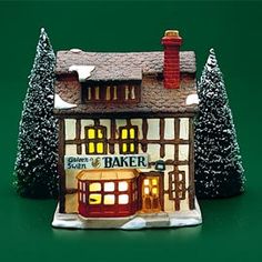 a small model of a bakery with trees and snow on the ground in front of it