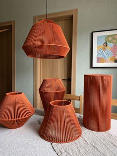 three orange vases sitting on top of a table