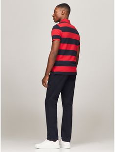 Tommy Hilfiger men's polo. What we do best, the classic polo in stretch pique cotton, cut in a trim, flattering fit and featuring a bold rugby stripe.  Material: 97% Regenerative Cotton. Cotton Polo Shirt With Contrast Stripes For Work, Cotton Polo Shirt With Horizontal Stripes, Cotton Polo Shirt With Signature Stripes, Fitted Striped Polo Shirt With Ribbed Collar, Classic Red Polo Shirt With Striped Collar, Sporty Striped Polo Shirt With Ribbed Collar, Fitted Striped Polo Shirt, Tommy Hilfiger Sporty Cotton Polo Shirt, Sporty Striped Cotton Polo Shirt