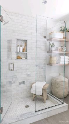 a bathroom with white brick walls and shelving on the wall, along with a wooden bench