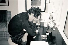 a woman sitting at a desk in front of a laptop computer with her hands on her face